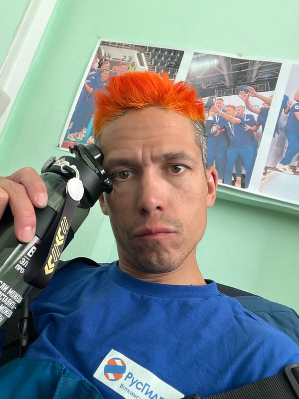 Orange-haired man takes selfie with water bottle in Chaikovsky
