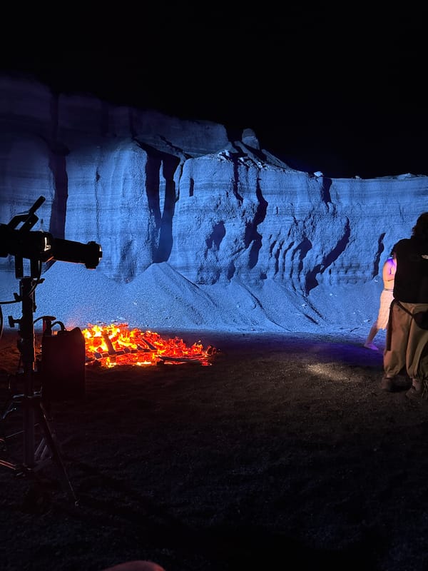 Two people rest near illuminated rock formation in Teguise