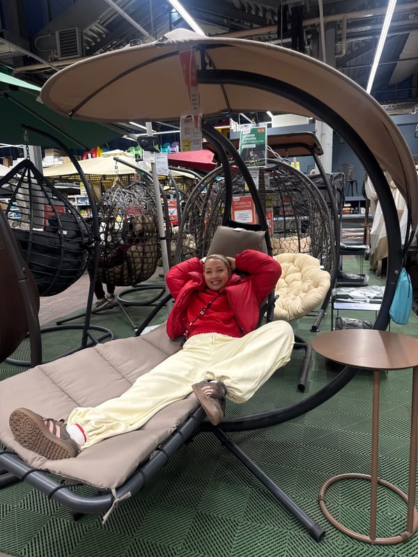 Woman relaxes on furniture display swing in Moscow store