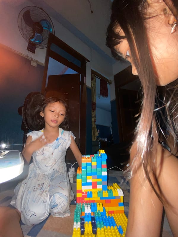 Child and adult play with building blocks in Gelam