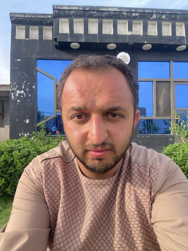 Man photographed in portrait session on grass in Kandahar