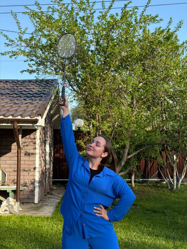 Family badminton gathering in Chaikovsky backyard during spring afternoon