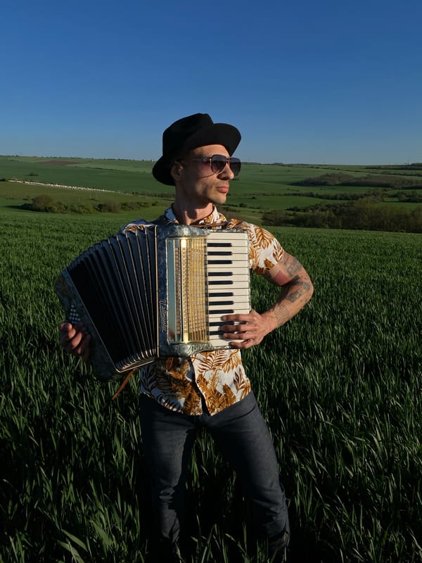Accordionist rests in Bulgarian field on spring afternoon