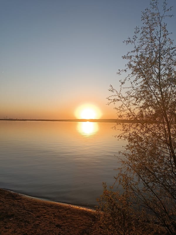 Woman captures sunset moments along Kama River in Chaikovsky