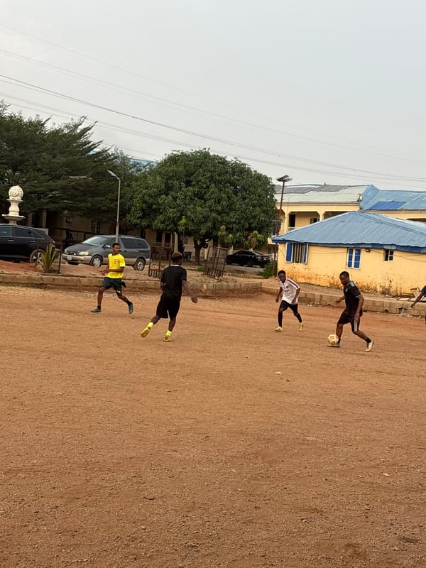 Young men play informal soccer match in Nigerian neighborhood