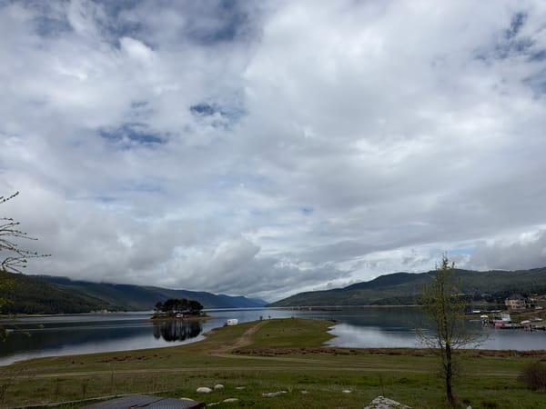 Morning clouds reflect across Lake Dospat, Bulgaria