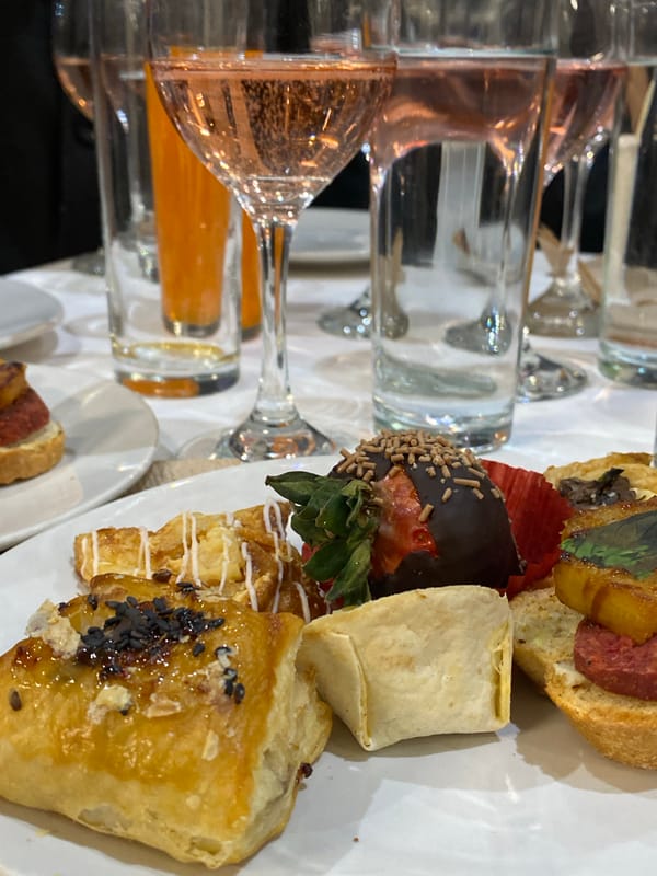 Dining scene with appetizers and pink beverages documented
