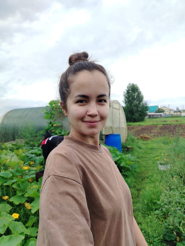 Casual portrait, slight smile, brown t-shirt, looking at camera