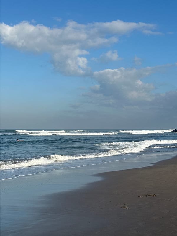 Surfer walks North Kuta beach with yellow board