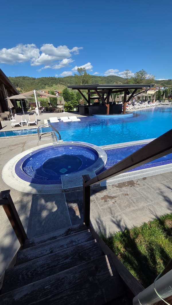 Person enjoys poolside leisure time with mountain backdrop