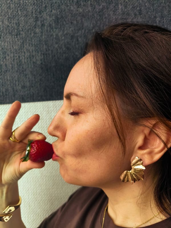 Woman's quiet moment and strawberry bite captured simultaneously