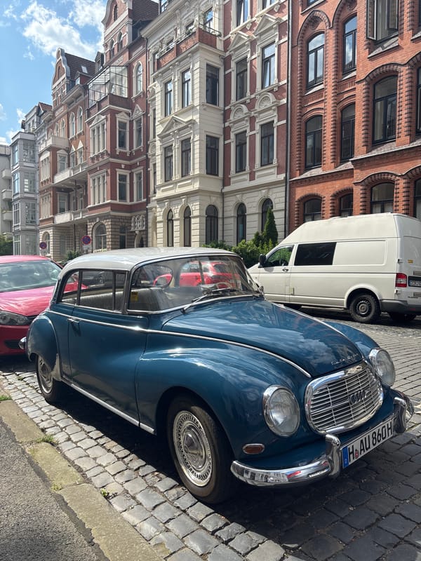 Vintage teal car parked on Hanover cobblestones