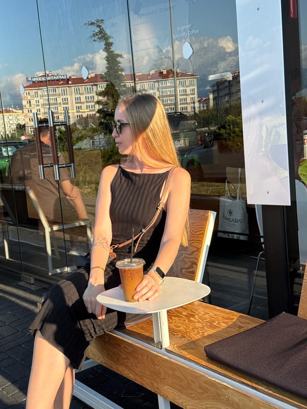 Woman enjoys iced coffee at outdoor cafe in Sochi