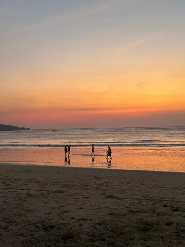 Golden hour at Kuta Beach, Bali — waves, silhouettes, sunset.