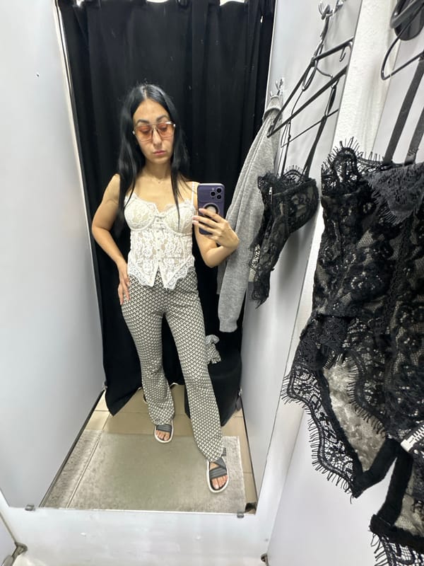 Fitting room try-on session with lace corset and flare pants