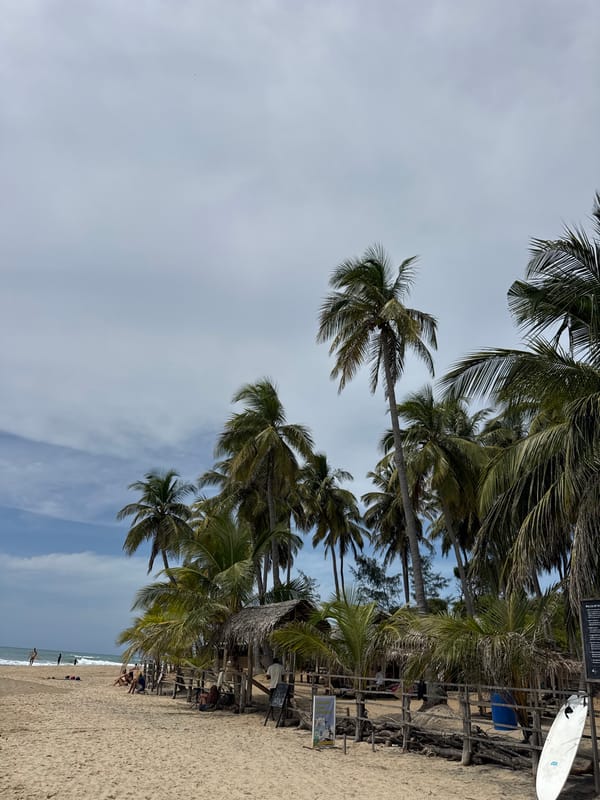 Surfing and beachgoers on a cloudy morning at Arugam Bay