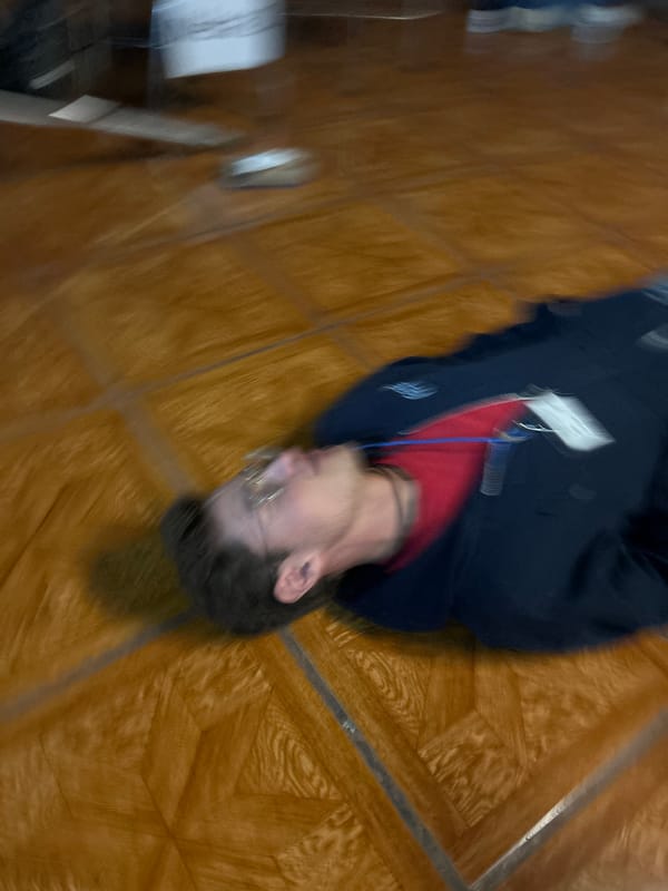 Person in red shirt lying on indoor floor
