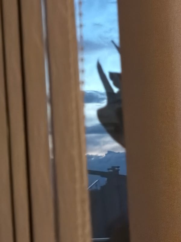Window view captures cloudy sky and crane in Plovdiv