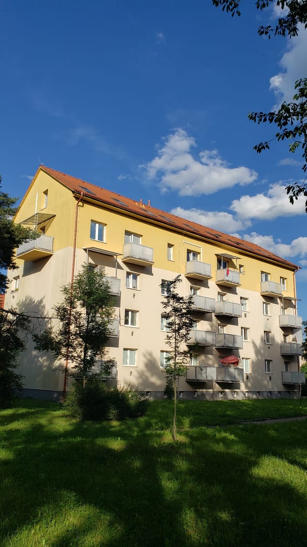 Street-level look at a graffiti-marked residential block in Prešov