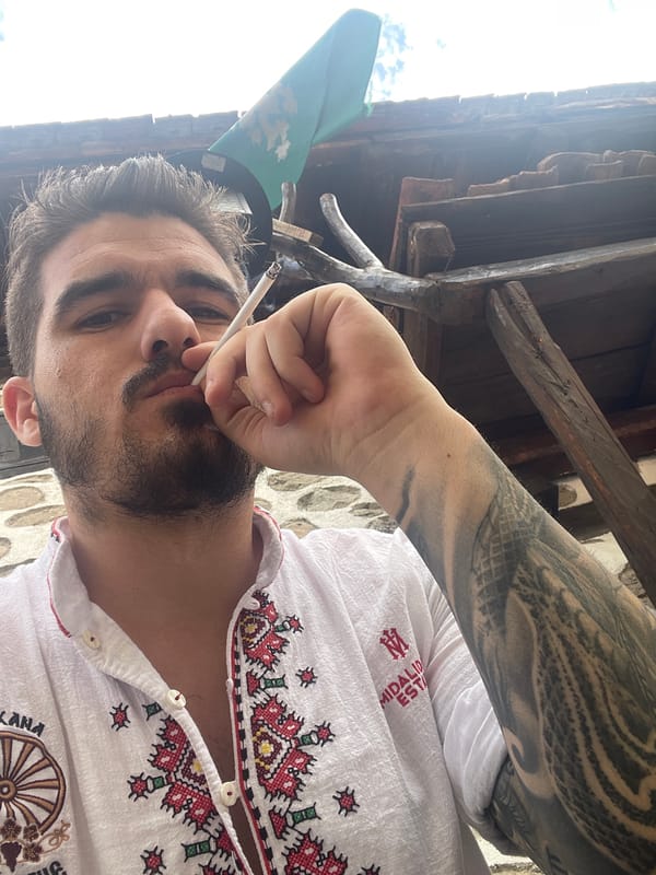 Man photographs himself smoking near kitchen with roasted peppers