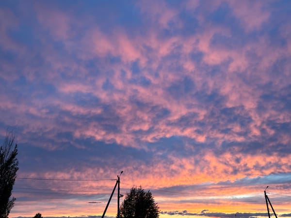 Dramatic sunset displays colorful clouds over residential area