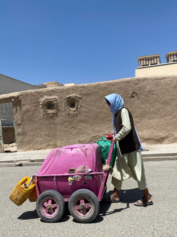 Street vendors and water containers on a Kandahar street