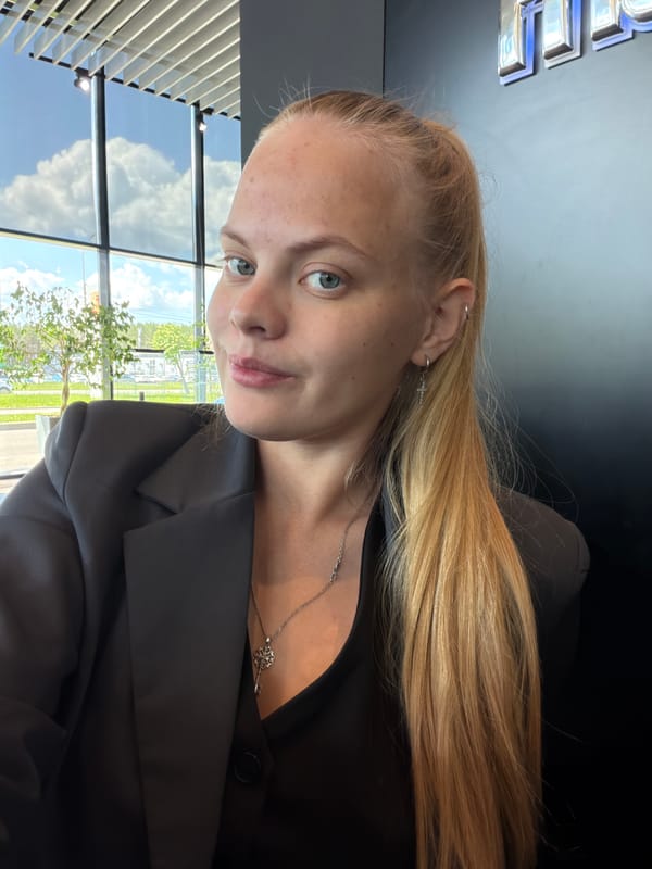 Woman in dark blazer observed sitting indoors in Izhevsk