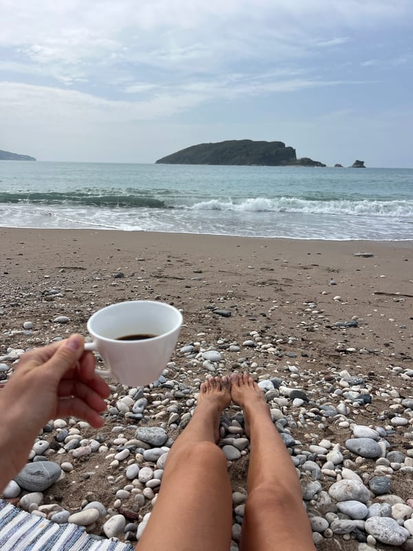 Person sits alone on overcast Budva beach morning