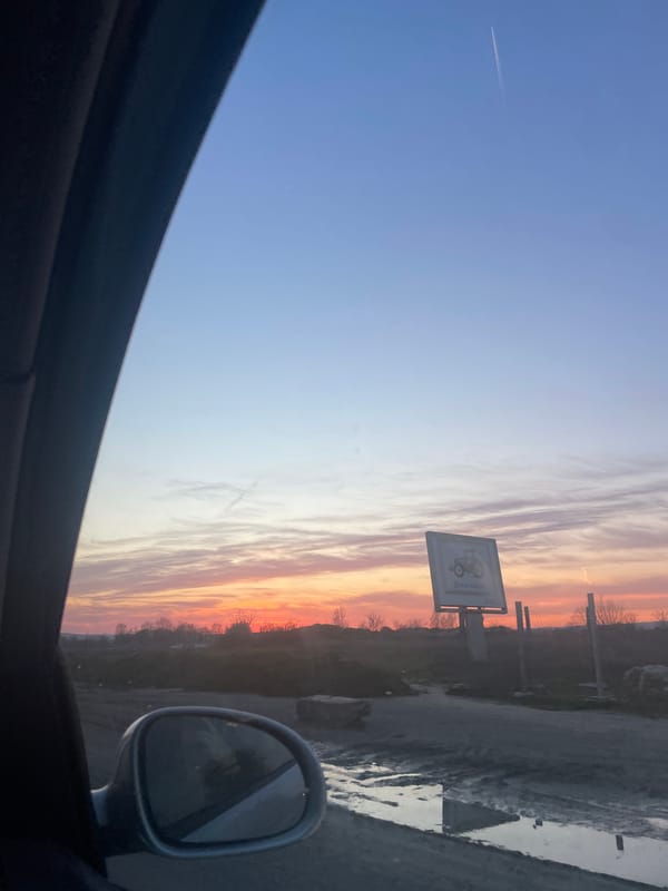 Sunset observed from vehicle in Nesebar, Bulgaria with aircraft contrail