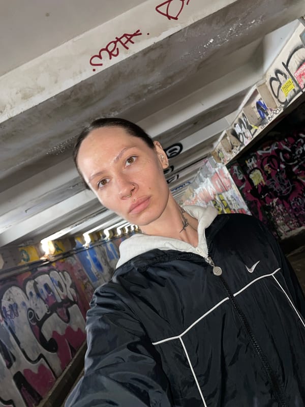 Person poses against graffiti wall in Izhevsk
