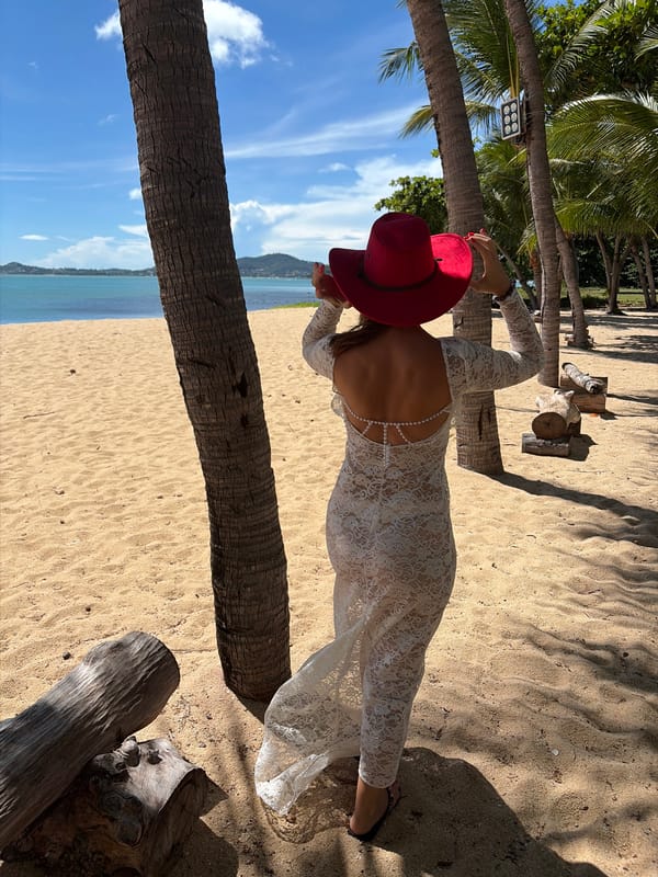 White lace dress and red hat on a Koh Samui beach