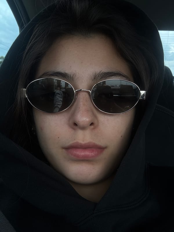 Person in sunglasses and hoodie spotted in vehicle interior