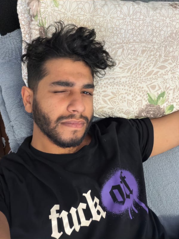 Man winks at camera while resting on pillow