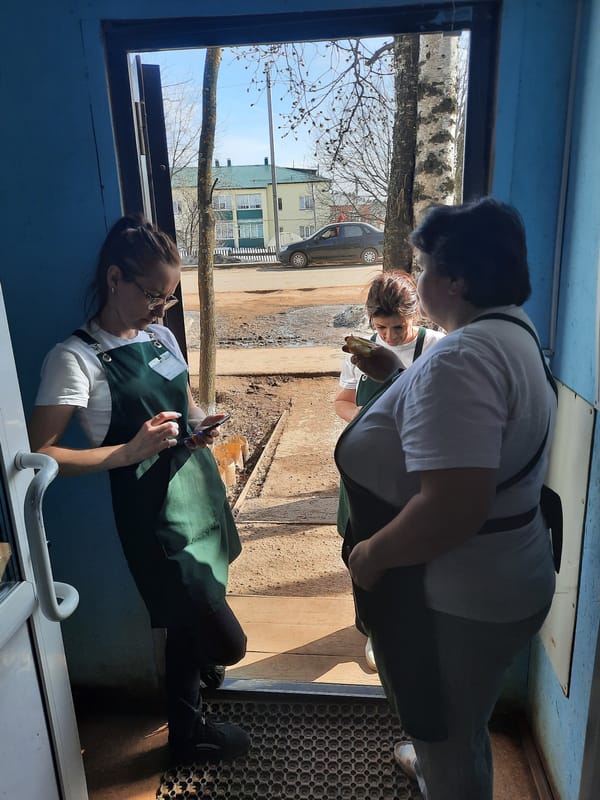 Woman with phone sits at window in Krasnogorskoye building