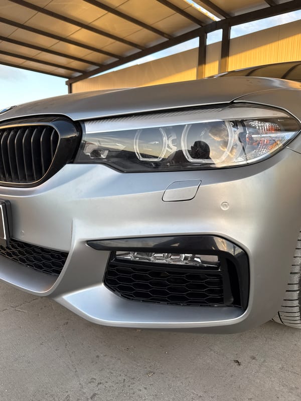 Luxury cars documented in covered parking area during sunset