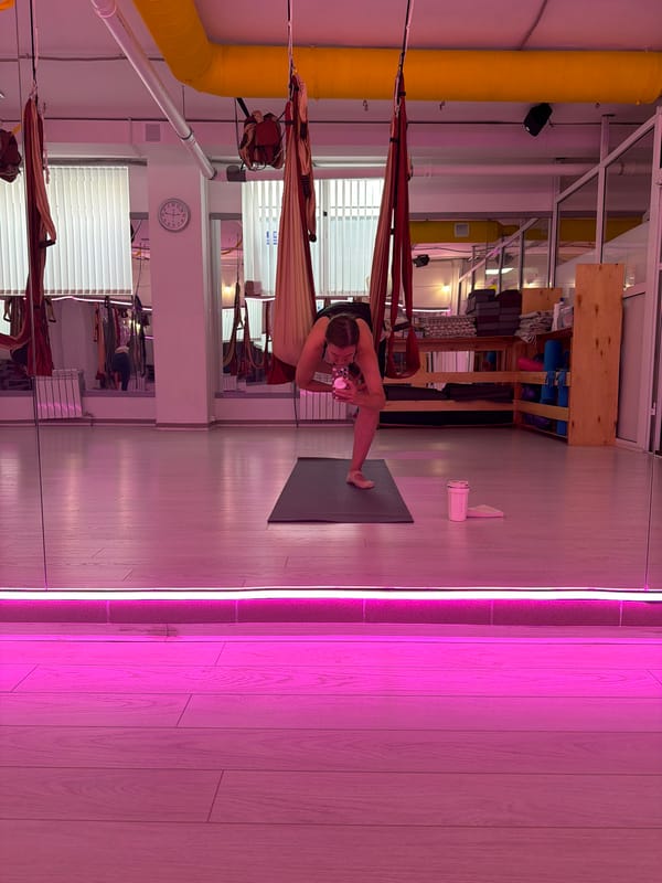 Aerial yoga session at a pink-lit studio in Chaikovsky
