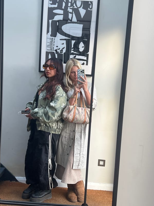 Two women captured in mirror reflection in London