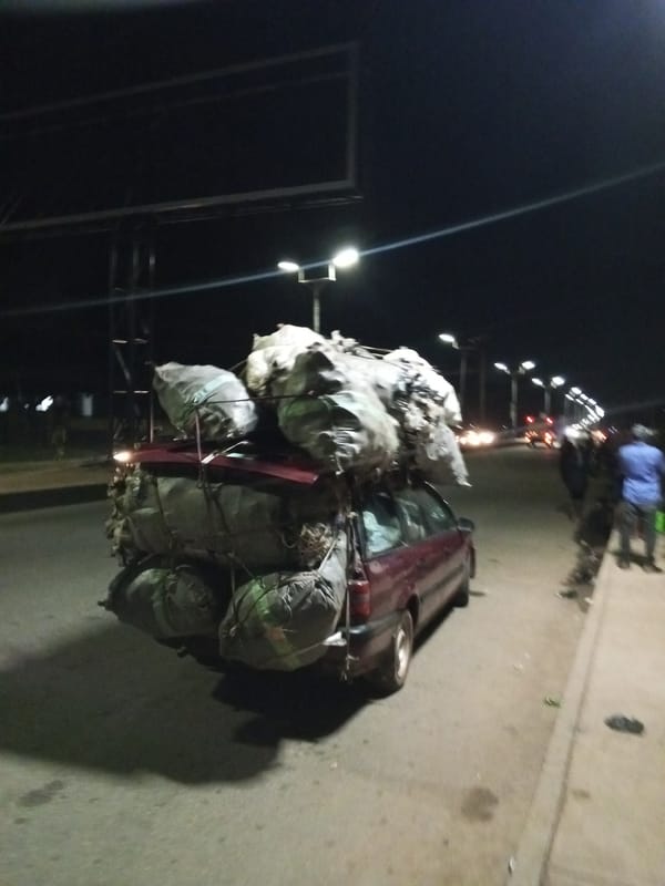 Heavy cargo transport, street vendors active during Bukuru evening hours