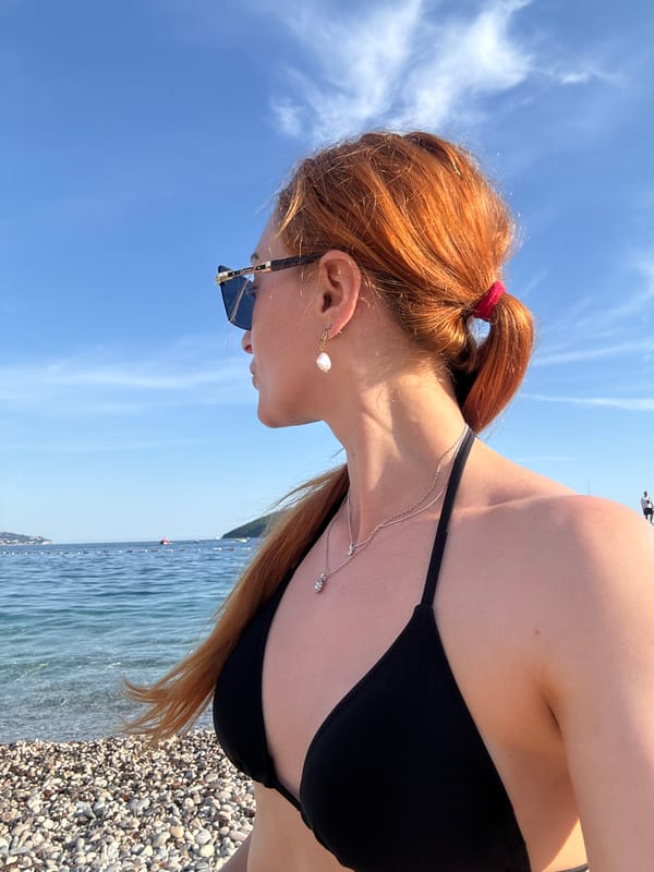 Woman poses with fan on Montenegro beach