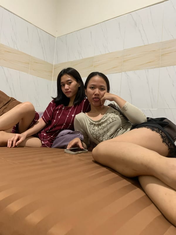 Two women rest on bed in Denpasar room