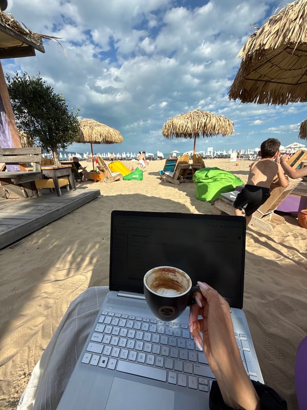 Woman works on laptop with coffee at Bulgarian beach