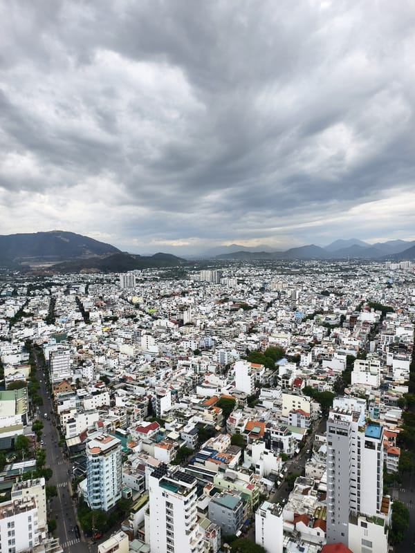 Aerial views document coastal city under overcast skies