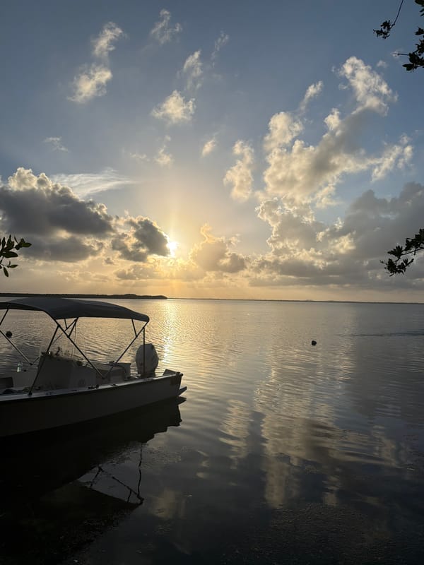 Sunset captured over Cancún waters with docked boat