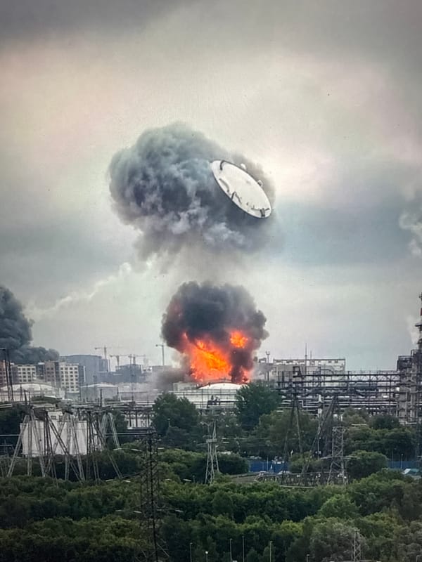 Industrial fire sends dark smoke across an urban skyline