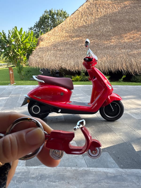 Red electric scooter spotted near thatched building in Kediri