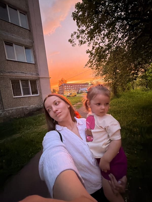 Mother and child enjoy sunset selfies in Reshetnikovo neighborhood