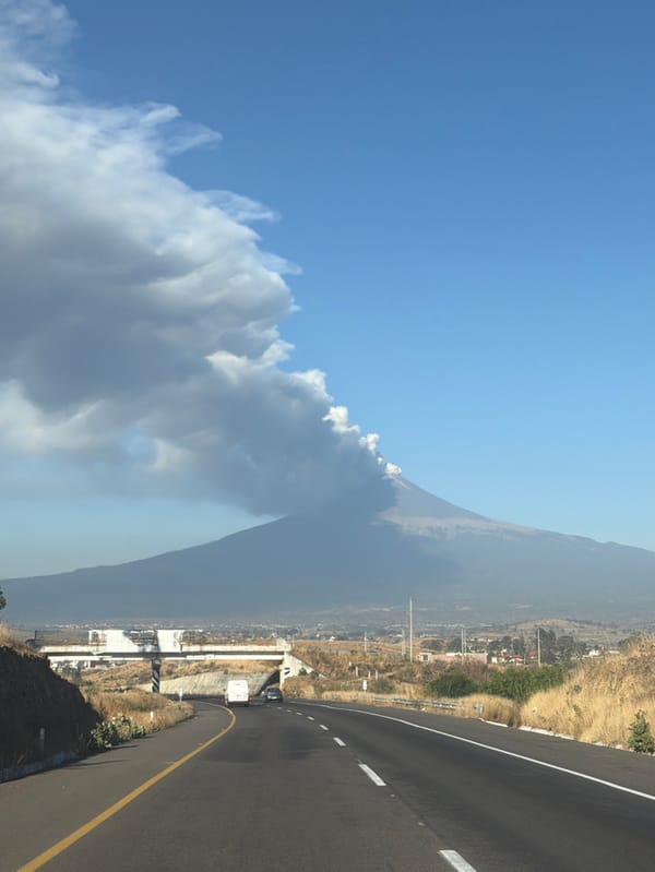 Volcano emits smoke near Mexican town, vehicles pass nearby