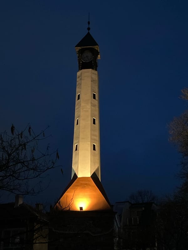 Pazardzhik Clock Tower illuminated during nighttime street scenes