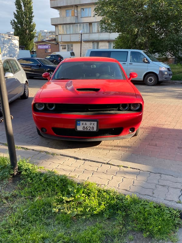 Red Dodge Challenger on cobblestones in Kyiv