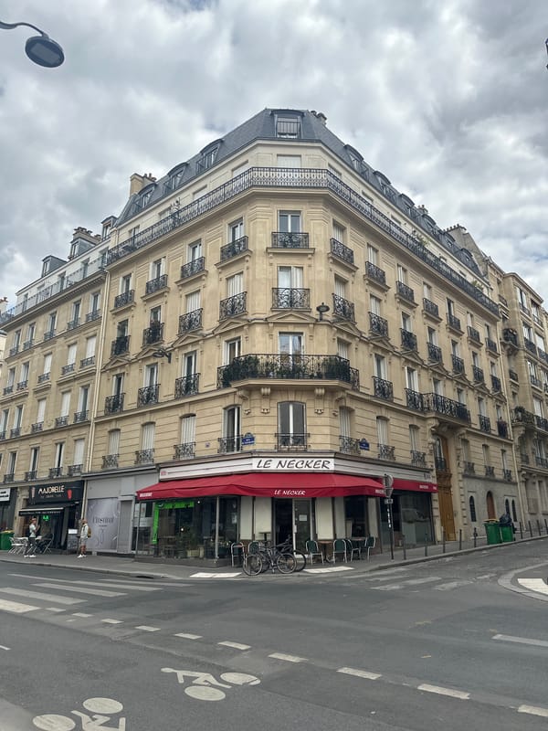 Paris streetscape: Haussmann facades, ornate stone, and a Tower glimpse